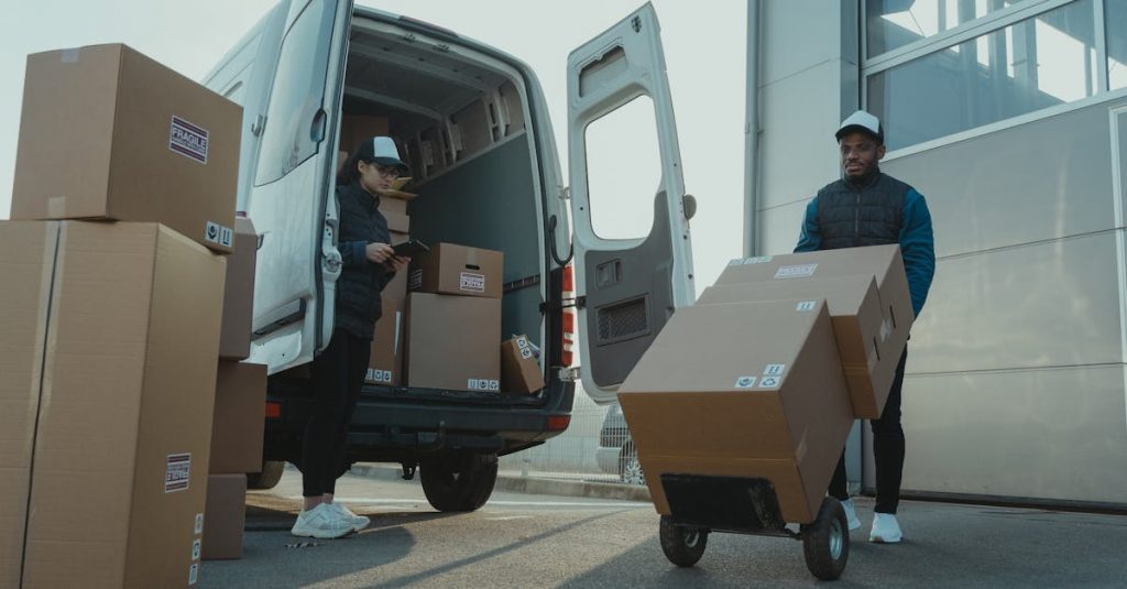 Two couriers load boxes into a van for shipment, showcasing logistics and teamwork.
